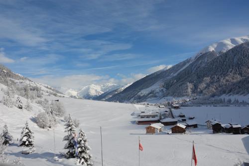 a ski lodge in the snow with mountains in the background at Hotel Restaurant Walliser Sonne in Reckingen - Gluringen