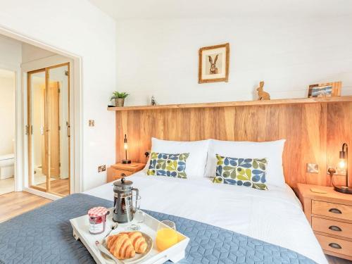 um quarto com uma cama com uma bandeja de comida em Viburnum Lodge em Willington