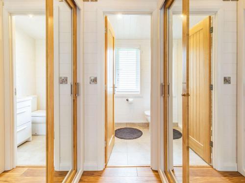 Habitación con baño con espejos y aseo. en Viburnum Lodge en Willington