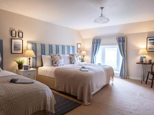 1 dormitorio con 2 camas y ventana en High Ranachan, en Campbeltown