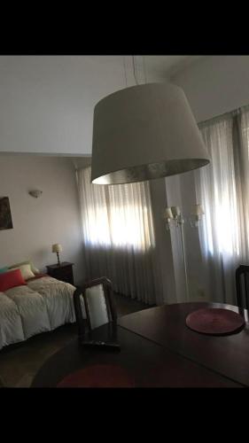 1 dormitorio con 1 cama, 1 mesa y 1 lámpara en Depto calle 8 en La Plata