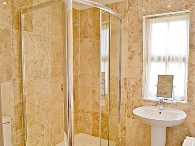 a bathroom with a shower and a sink at Darling Cottage in Bamburgh