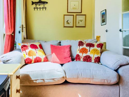 - un canapé avec des oreillers dans le salon dans l'établissement Foxgloves Bungalow Uk39618, à Welcombe