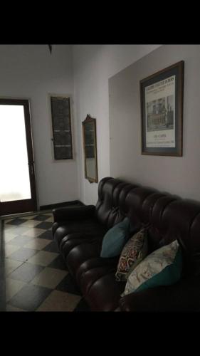 sala de estar con sofá de cuero y ventana en Depto calle 8 en La Plata