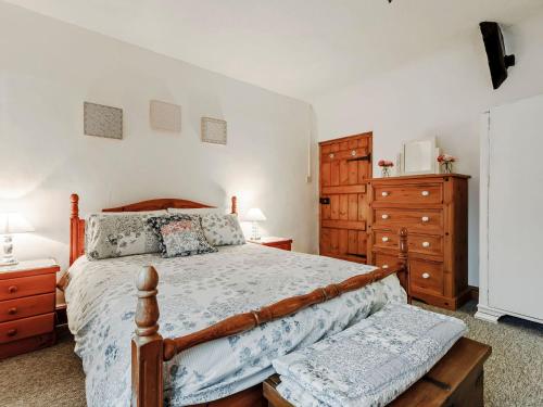 a bedroom with a wooden bed and wooden dressers at The Cottage in Wells