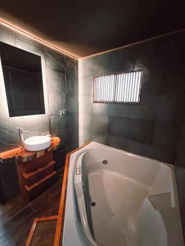a bathroom with a bath tub and a sink at Bocalago in Puerto Nuevo