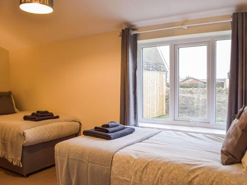 a bedroom with two beds and a large window at Y Glowty in Maenclochog