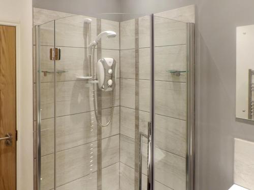 a shower with a glass door in a bathroom at Wee Glebe in Moniaive