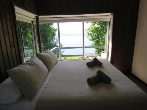 a bedroom with a large bed with two black objects on it at Bocalago in Puerto Nuevo