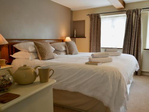 ハートランドにあるThimble Cottageのベッドルーム1室(白いシーツ付きのベッド1台、窓付)