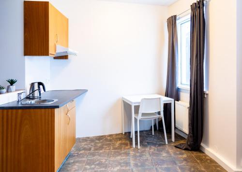 uma pequena cozinha com uma mesa e uma janela em Westman Islands Inn em Vestmannaeyjar