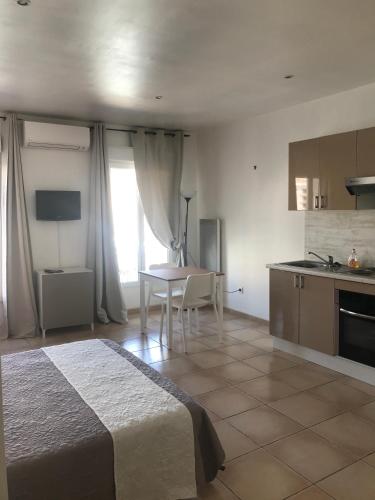 une chambre avec un lit et une table et une cuisine dans l'établissement Studio 2ème étage vue sur Quai et Mont Saint Clair, à Sète