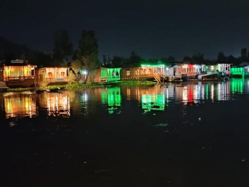un groupe de maisons sur l'eau la nuit dans l'établissement HB king of kings, à Srinagar