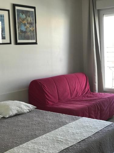 - un canapé rouge dans une chambre avec fenêtre dans l'établissement Studio 2ème étage vue sur Quai et Mont Saint Clair, à Sète