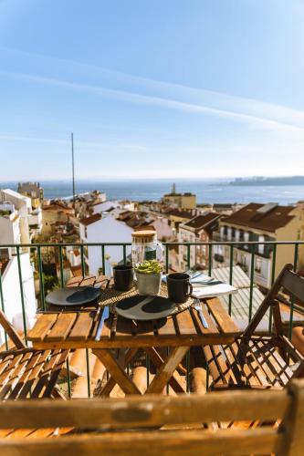a wooden table with two plates of food on a balcony at Olympo Shared flat with Amazing River view in Lisbon