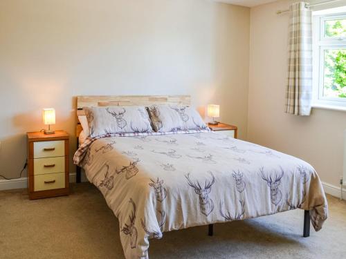 Dovecote Annex في مابليتورب: غرفة نوم بها سرير ومصباحين على الطاولات