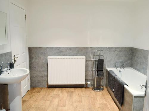 a bathroom with a tub and a sink and a bath tub at Garden Cottage in Tain