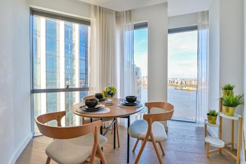 a dining room with a table and chairs and large windows at ShyPen in London