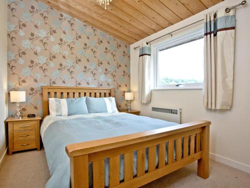 a bedroom with a large bed and a window at Garfield Lodge in Hawkchurch