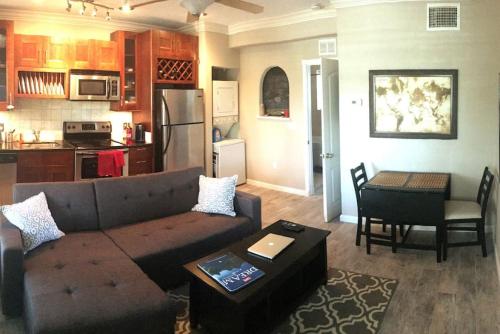 a living room with a couch and a table and a kitchen at Walk Everywhere Heart of Downtown St Pete in St. Petersburg