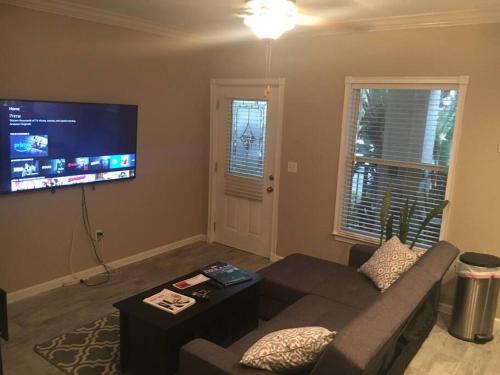 a living room with a couch and a flat screen tv at Walk Everywhere Heart of Downtown St Pete in St Petersburg