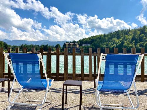 two blue chairs and a table in front of a fence at Garni Il Muretto in Lavarone
