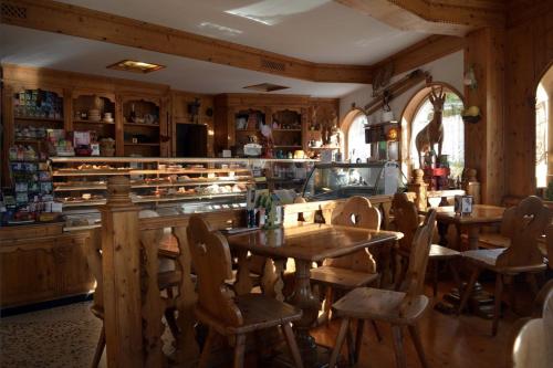 een restaurant met een tafel en stoelen in een kamer bij Garni Il Muretto in Lavarone