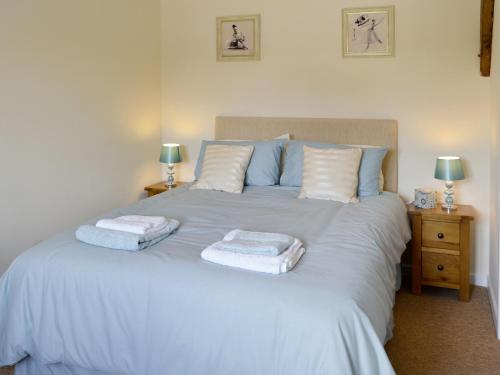 a bedroom with a white bed with towels on it at Casterbridge - 29955 in Wootton Glanville