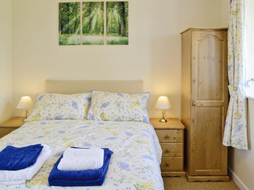 a bedroom with a bed with two towels on it at Casterbridge - 29955 in Wootton Glanville