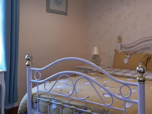 1 dormitorio con 1 cama con marco azul en Old Barn Farm Cottage en Uplawmoor