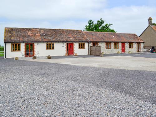 a white building with red doors and a driveway at Casterbridge - 29955 in Wootton Glanville