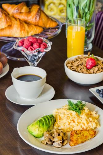 een tafel met borden met ontbijtproducten en drankjes bij 1 Lexham Gardens Hotel in Londen