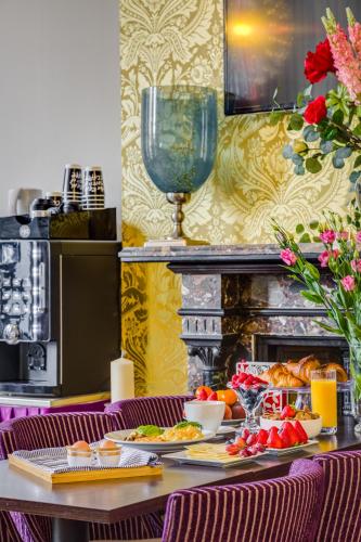 een tafel met daarop borden met eten bij 1 Lexham Gardens Hotel in Londen