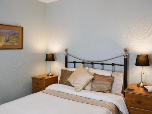 ein Schlafzimmer mit einem Bett und zwei Nachttischen mit Lampen in der Unterkunft Blencathra House in Keswick