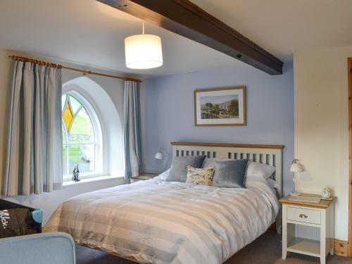a bedroom with a large bed with a window at The Old Chapel in Aysgarth