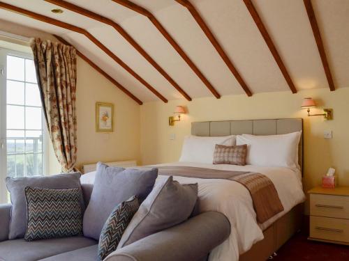 1 dormitorio con 1 cama grande y 1 sofá en Meadow Croft, en Llangeinor