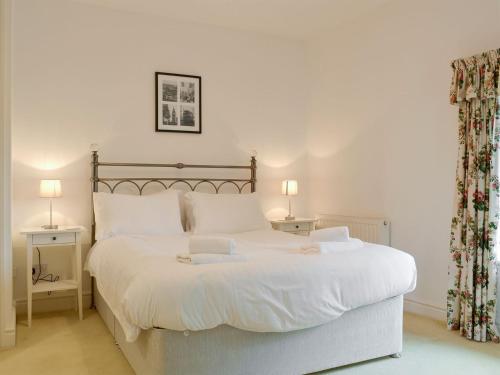 - une chambre avec un grand lit blanc et des draps blancs dans l'établissement Leyfield Coach House, à Kirkby Lonsdale
