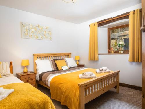 a bedroom with two beds and a window at Oak Cottage in Beckermonds