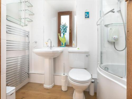 a bathroom with a toilet and a sink and a tub at Oak Cottage in Beckermonds