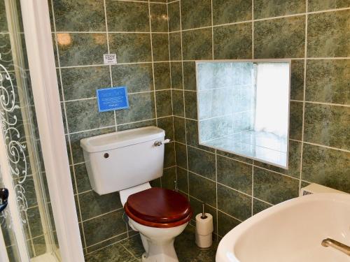 a bathroom with a toilet and a sink and a tub at Aubretia Trail-mjb in Akeld