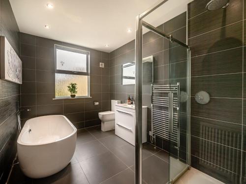 a bathroom with a tub and a toilet and a shower at Babbacombe House in Torquay