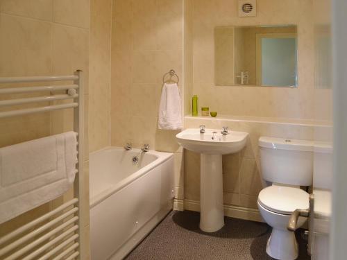 a bathroom with a sink and a toilet and a bath tub at The Loft in Kirkby Lonsdale