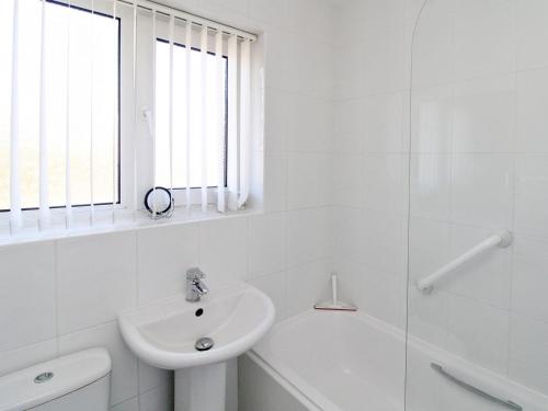 a white bathroom with a sink and a toilet at Kingsway Court in Seaford