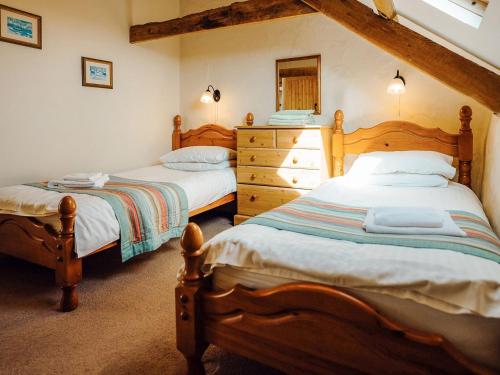 a bedroom with two beds and a dresser at Servants Quarters - Uk6725 in Lydstep