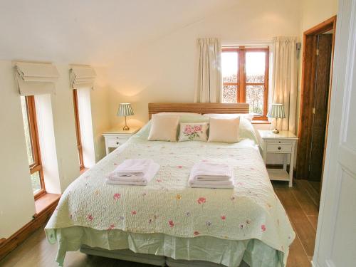 1 dormitorio con 1 cama con 2 toallas en The Garden Apartment - 28342, en Neatishead
