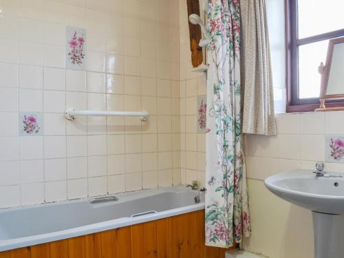 a bathroom with a bath tub and a sink at No,3 Halford Farm in Halford