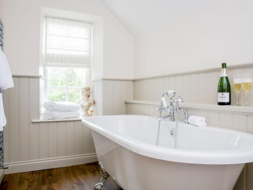 a white bath tub in a bathroom with a window at Garden Cottage in Settrington