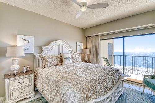 a bedroom with a bed and a balcony at The Palms #1002 in Orange Beach