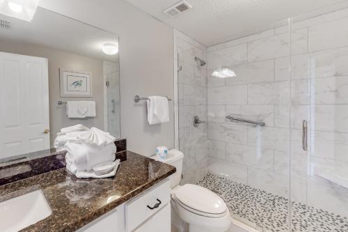 a bathroom with a toilet and a sink and a shower at The Palms #1002 in Orange Beach