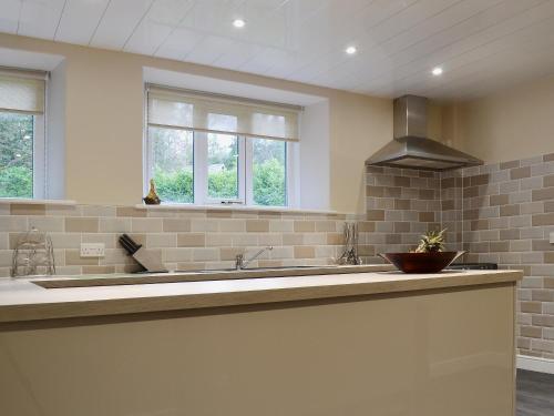 a kitchen with a large sink and two windows at Corner Cottage - Lp2 in Windermere